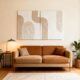 تابلو دکوراتیو بافت‌دار مینیمال دوتکه، بژ و کرم، نصب شده بالای کاناپه مخمل قهوه‌ای در دکوراسیون مدرن و شیک.